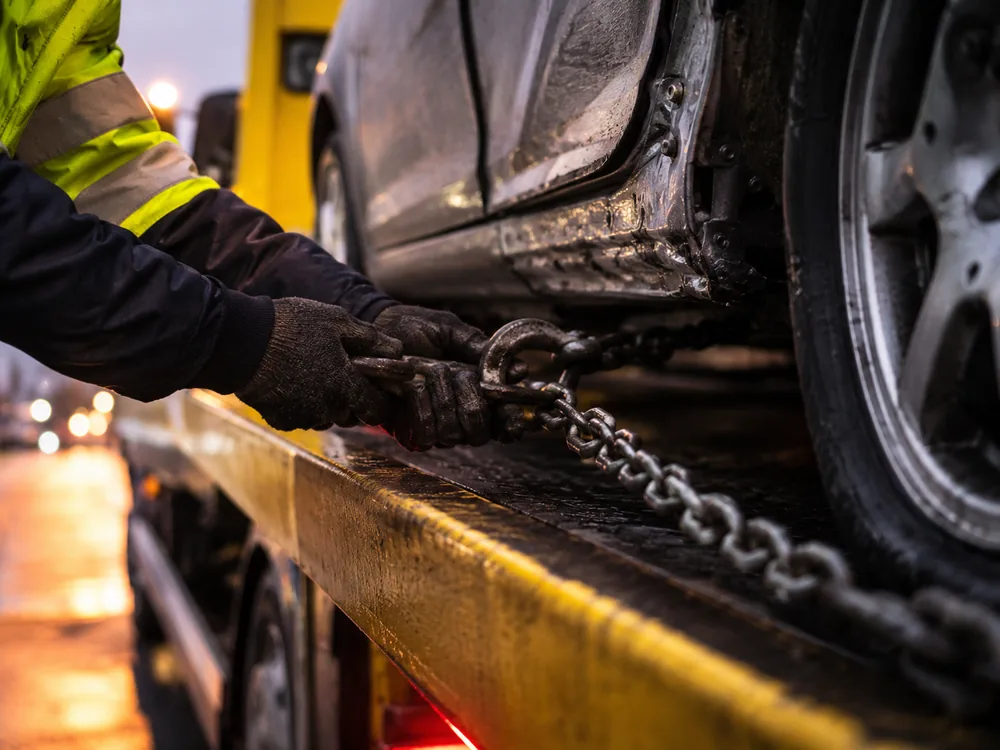 Chargement d'une épave sur le plateau d'une dépanneuse